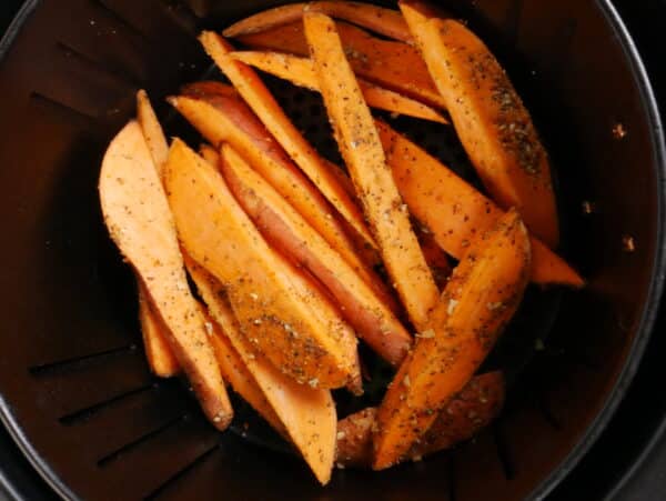 image of an air fryer basket with sweet potato wedges