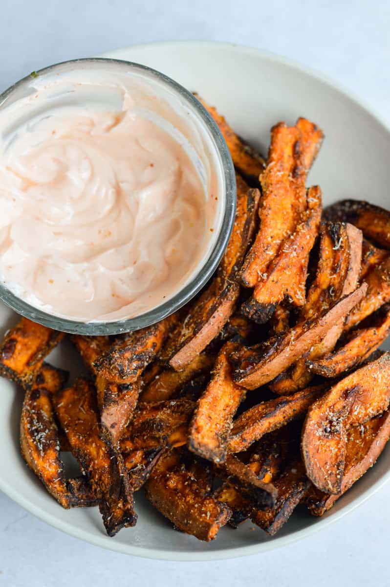 Image of a white plate of Air Fryer Sweet Potato Wedges with dip