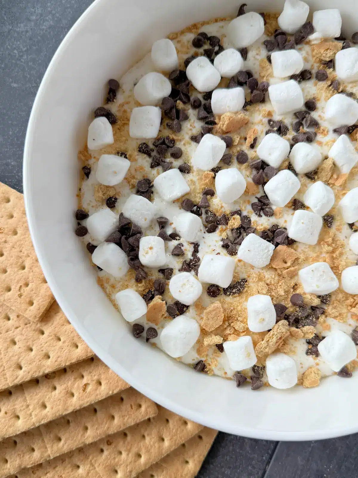 Image of a bowl with cottage cheese smores dip and some graham crackers on the side