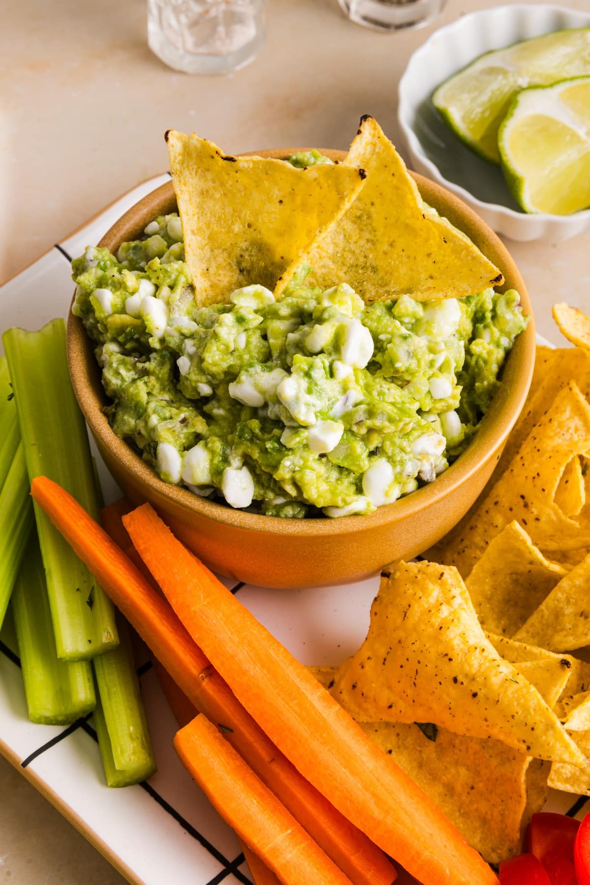 image of a bowl filled with cottage cheese guacamole and some veggies and chips