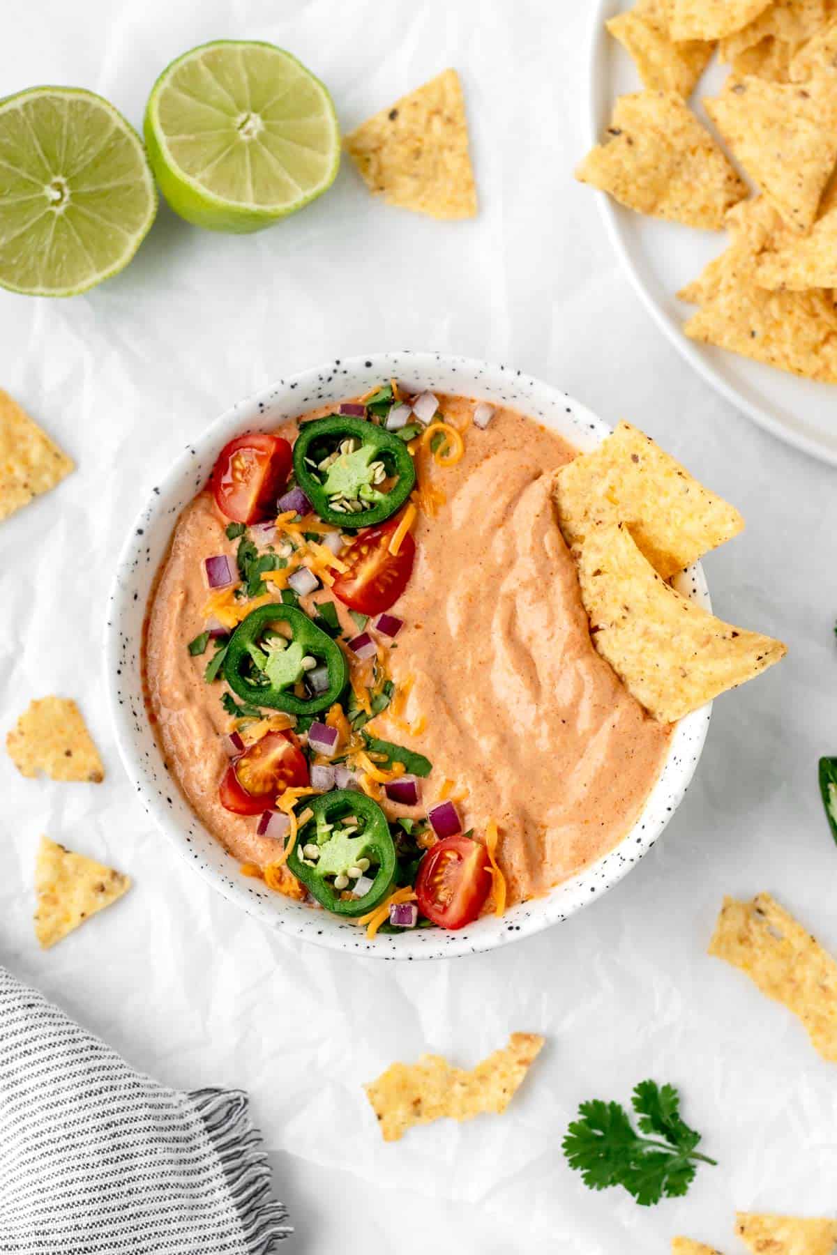 image of a bowl filled with cottage cheese queso and some garnishes